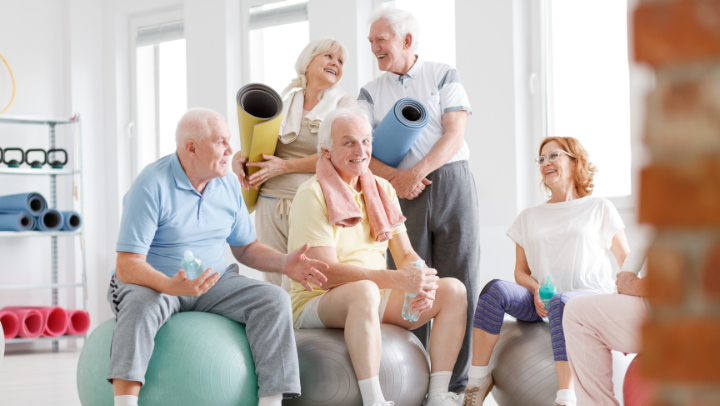 a group of seniors smiling at each other after doing yoga