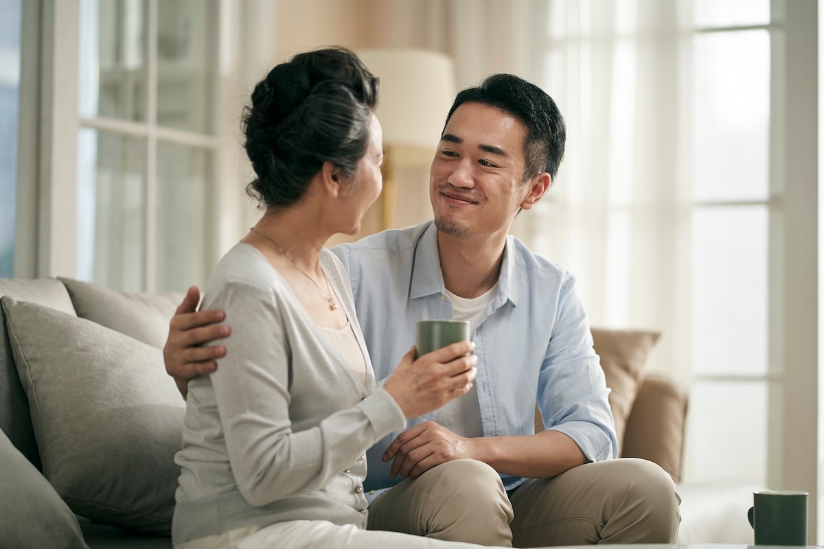 Adult children comforting his elderly mom about a senior living transition